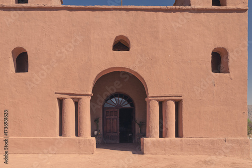 Historic adobe church with twin bell towers against mountains