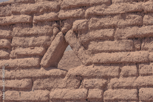 Triangular opening in a textured adobe wall frames