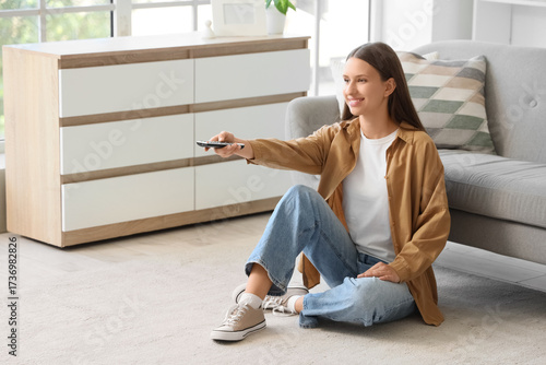 Young woman with remote con...