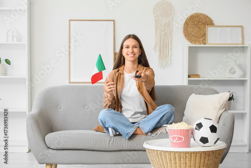 Young woman with TV remote ...
