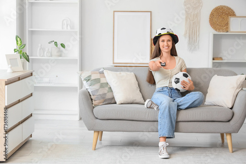 Young woman with TV remote ...