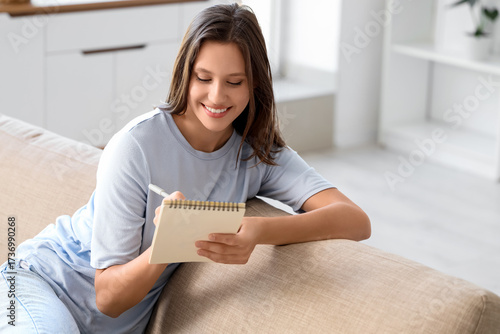 Young woman writing in note...