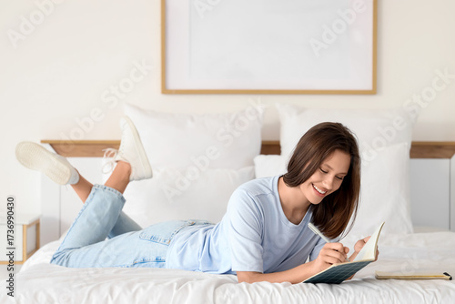 Young woman writing on note...