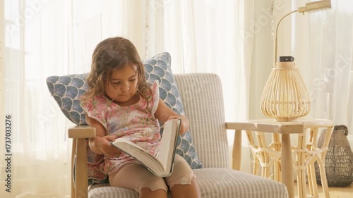 Toddler Reading a Book on Chair in Bright Coastal Home