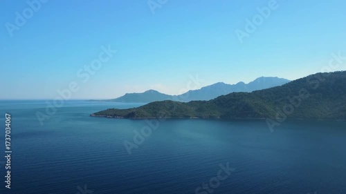 Wallpaper Mural aerial view showcasing the tranquil turquoise waters of the Mediterranean Sea meeting the rugged, green clad mountains and a picturesque island coastline near Adasi, Turkey. Torontodigital.ca