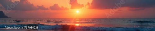 Sunset over placid ocean; gentle waves, hazy sky, coast, sunset