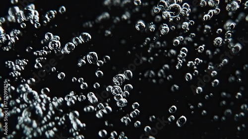 A captivating close-up of bubbles rising in liquid, set against a dark background, showcasing their intricate shapes and formations.
