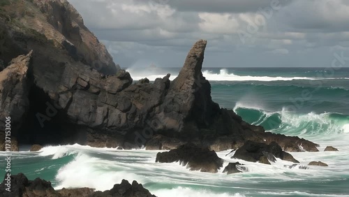 Powerful Ocean Waves Crashing Violently Against Dark Jagged Coastal Rock Formations