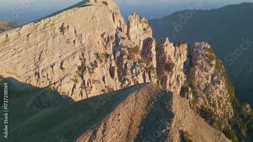 Aerial sunrise footage of mountain peaks with dramatic shadows and glowing ridges. Serene landscape perfect for documentaries, travel films, and adventure content.
