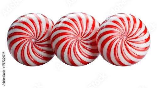 Three peppermint candies with red and white spirals isolated on black background