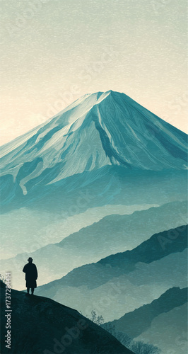 Man standing on a mountain peak gazing at Mount Fuji in Japan with misty mountains around