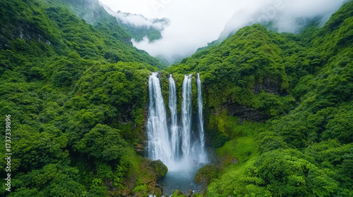 Majestic waterfall cascading through lush greenery, surrounded by misty mountains and vibrant
