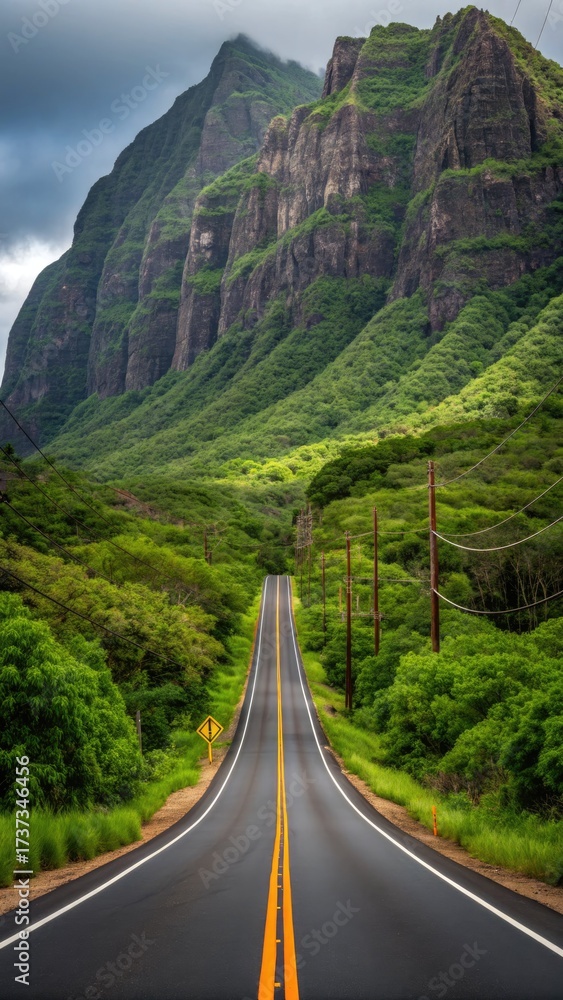 Fototapeta premium Scenic highway leading through lush green mountains under a dramatic cloudy sky