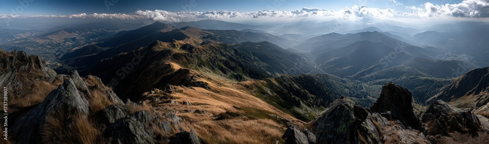 Naklejka premium A blurred image of mountains with sunlight through the clouds