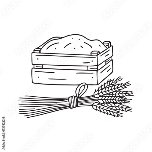 A wheat bundle near a wooden crate filled with harvested crops