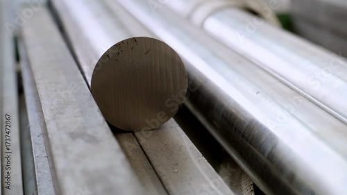 Close-up of a stack of cylindrical metal bars and rods, showing the raw materials for machining and industrial supply storage in a factory