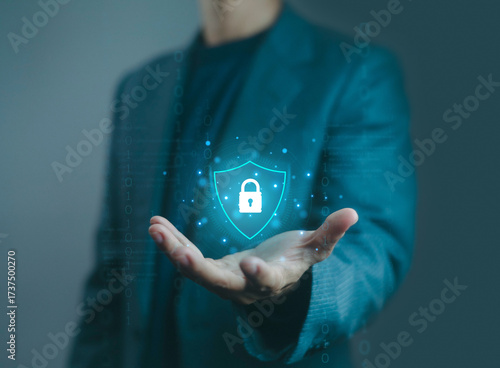 Businessman hand holding digital shield with padlock icon, representing cybersecurity, data protection, secure network, online privacy, encryption, and modern information technology security.