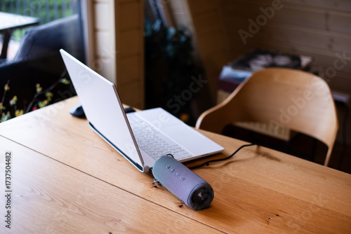 Laptop on the table. Workplace in the office or freelancer. Portable audio speaker.