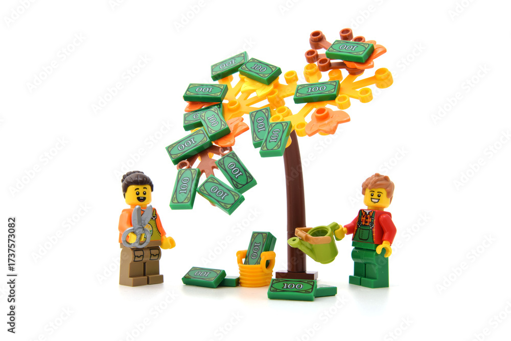 Obraz premium Lego minifigure of happy male and woman are collecting of money from tree as green banknotes isolated on white. Editorial illustrative image of finance or light money.