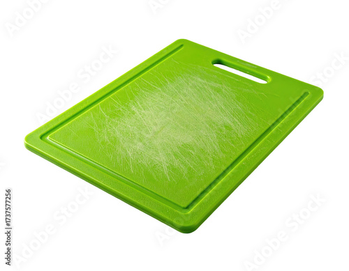 An angled, worn, green rectangular cutting board with a handle slot, on black