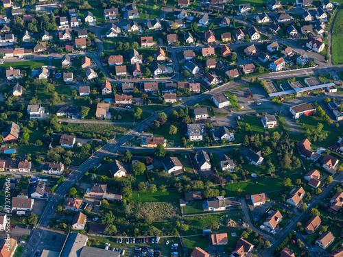 Wallpaper Mural Aerial view of houses with red rooftops nestled among vibrant green trees and pathways creating a picturesque scene, Thann, Grand Est, France. Torontodigital.ca