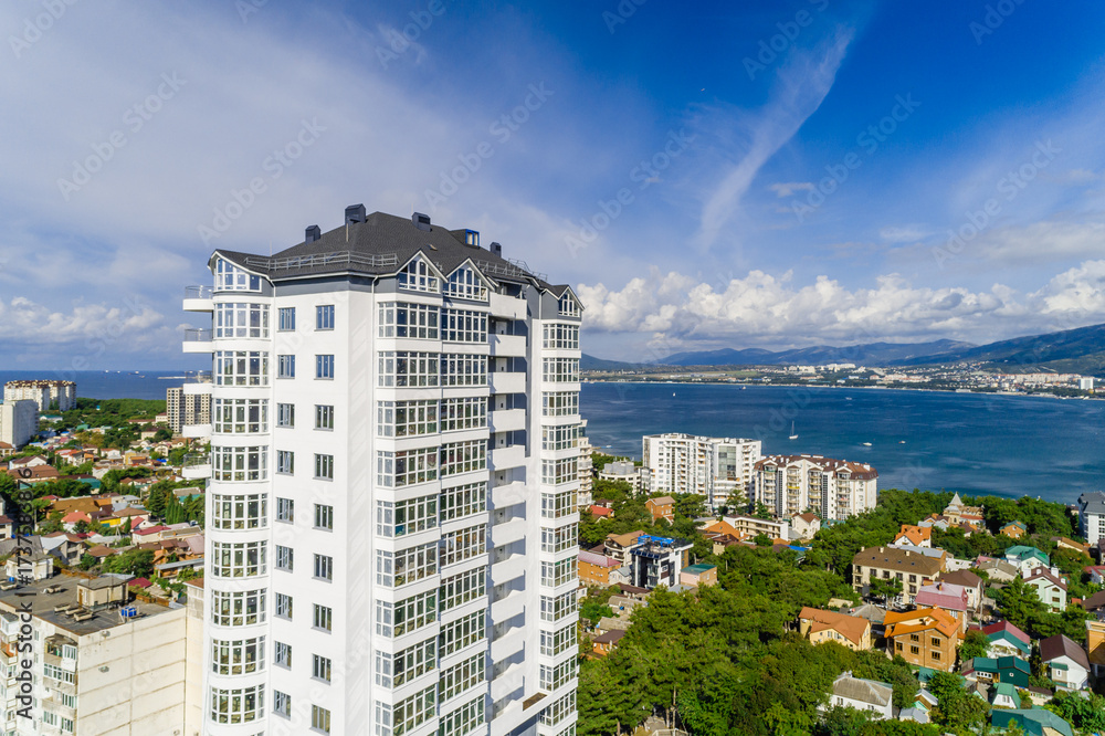 Fototapeta premium New multi-storey residential building in resort of Gelendzhik. Aerial view. View of Black Sea, Gelendzhik Bay and Caucasus Mountains.