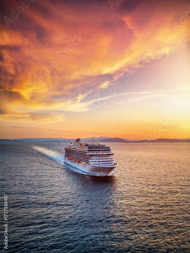 Beautiful aerial summer sunset view of a generic cruise ship traveling over the calm ocean with copy space