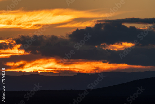 Dramatic Sunset with Wind Turbines on Horizon