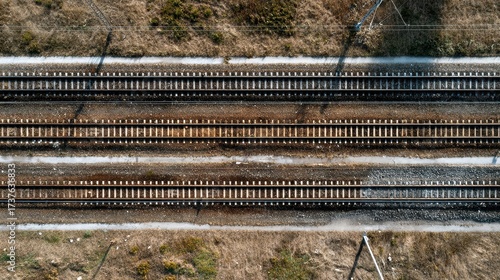 Top Down Aerial View of Parallel Railway Tracks Through Arid Landscape