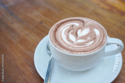 A cup of coffee with latte art on a wooden table
