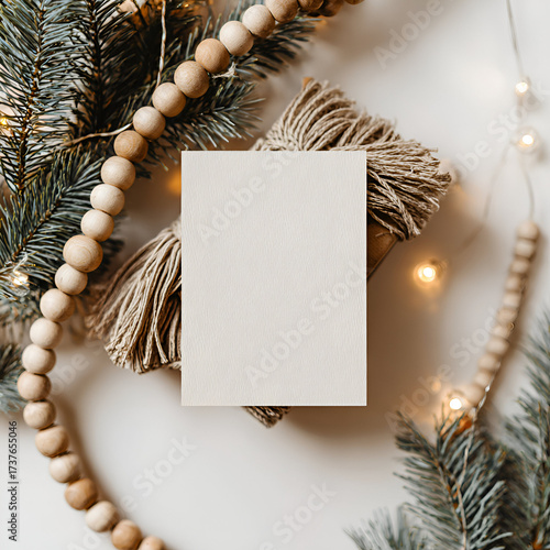 Rustic Christmas mockup with wooden beads, pine branches, and blank invitation card