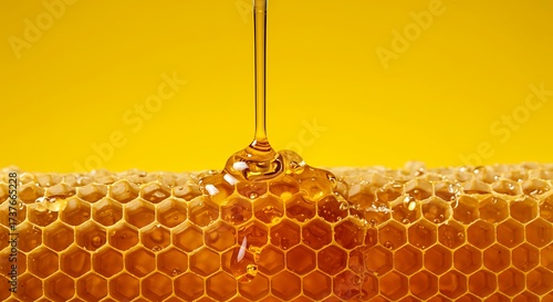 Honey dripping from a honeycomb against a yellow background
