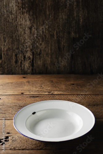 Isolated White Plate on Wooden Table Against Dark Background