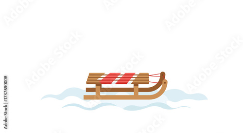 Classic wooden sled with red straps on a snowy ground.