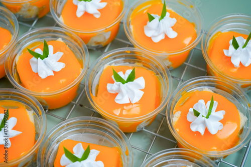 Orange ball cake placed on a grid on a green background.