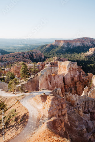 Bryce Canyon at first light, panorama from Rim Trail at Sunrise Point over canyon, contre-jour shot into sun with lens flares and copy space