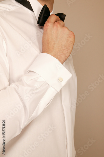 Man adjusting his bow tie and cufflink