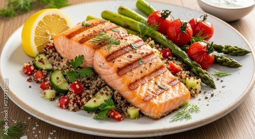 Freshly grilled salmon fillet, served with quinoa, diced cucumbers and red peppers, accompanied by cherry tomatoes, asparagus spears, and a lemon slice, presenting a healthy and delicious meal on a...