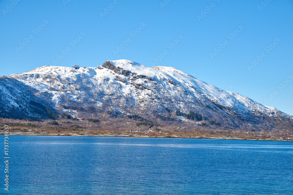 Obraz premium Ocean, mountain and landscape with blue sky in nature, outdoor and mockup space for travel. Holiday, vacation and winter environment with sea, snow and water for tourism in countryside in Norway