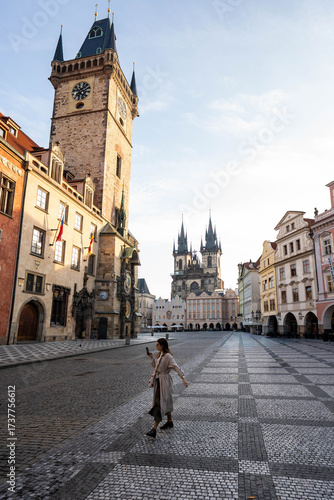 Stunning sunrise over Prague with warm golden light illuminating historic architecture, cobblestone streets, and iconic city landmarks in high-quality detail.