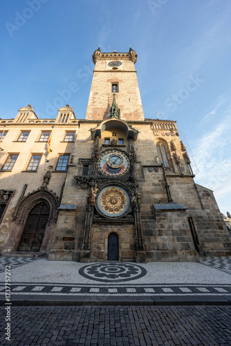 Stunning sunrise over Prague with warm golden light illuminating historic architecture, cobblestone streets, and iconic city landmarks in high-quality detail.