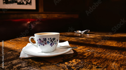 Espresso in porcelain cup on antique wooden café table
