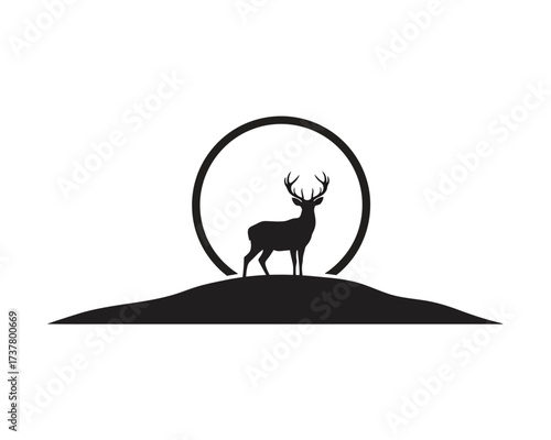 Elegant silhouette of a proud stag with large antlers standing on a hill against a circular sun