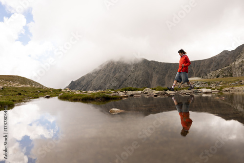 Wallpaper Mural A man in a red jacket is walking on a mountain trail Torontodigital.ca