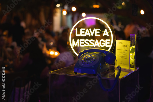 Retro phone guestbook station with neon sign at event
