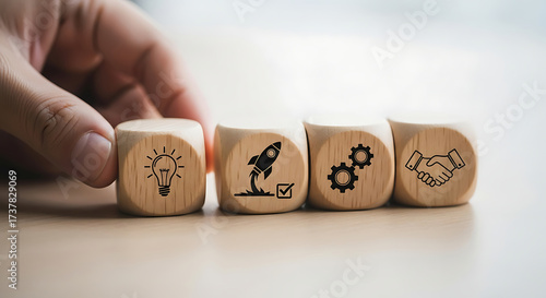 Hand places wooden block with lightbulb icon starting a business sequence startup idea