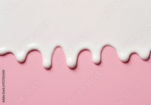 White creamy liquid dripping down over a pastel pink background.