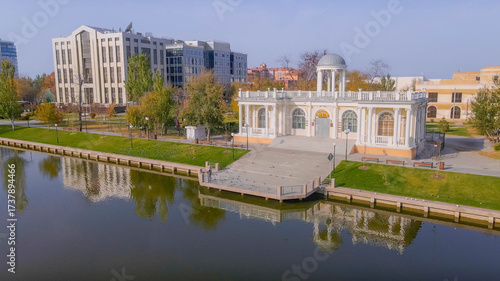 Fotografía Pavilion on Swan Lake in Astrakhan, Russia, with Lukoil office, green park, autumn day at city business district