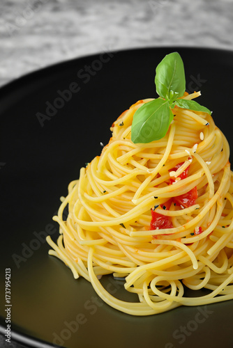 A pile of noodles on a black plate