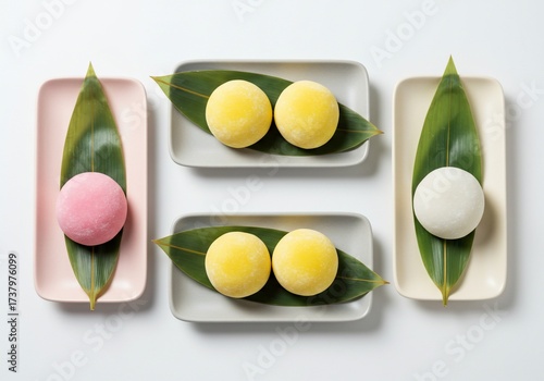 Assortment of colorful Japanese mochi desserts on rectangular plates.